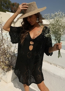 Détail de la robe de plage noire au crochet avec col en V profond et motifs ajourés ronds