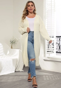 Detail of a creamy white thick knit cardigan showing the cozy chunky texture and long sleeves