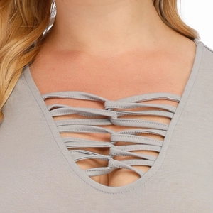 Détail d'une robe gris clair avec un décolleté plongeant en V et des lanières croisées