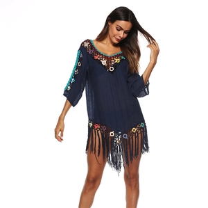 Detail of navy blue beach cover-up featuring colorful crochet trim and long tassel hemline