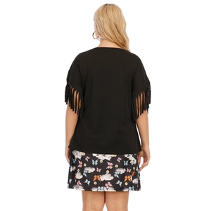 Detail view of the fringe cuffs on the black t-shirt and floral butterfly print skirt