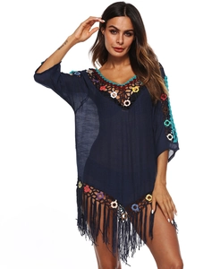 Close-up of bohemian blue beach cover-up with crochet neckline and long tassels