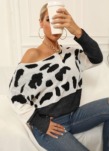 Detailed close-up of chunky knit sweater with black and white animal print texture