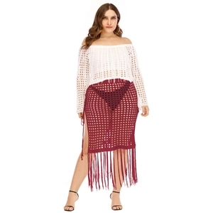 Detail of burgundy crochet skirt featuring high side slit and long tassel fringe trim