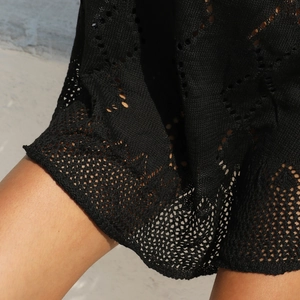 Détail de la robe de plage en crochet noir avec des motifs de tricot ajourés en losange
