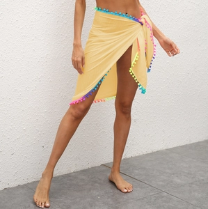 Paréo de plage jaune clair avec bordure à pompons colorés pour couvrir les maillots