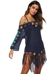 Detail of dark blue beach cover-up with crochet lace, colorful rings and long tassels