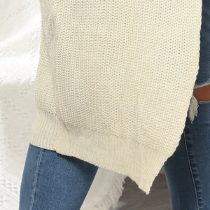 Close-up of beige chunky knit cardigan showing thick texture and woven hem detail