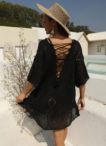 Détail d'une robe de plage en crochet noir avec dos lacé et motifs ajourés élégants