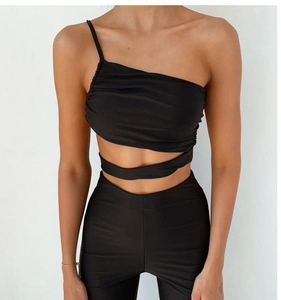Detail of black one-shoulder crop top with pleated chest and waist cutout crisscross ties
