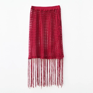 Detail of burgundy crochet hollow knit skirt with long fringe tassels and side lace-up tie