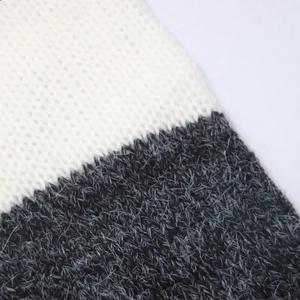 Dettaglio del tessuto a maglia con trama bianca liscia e consistenza grigia pelosa in mohair