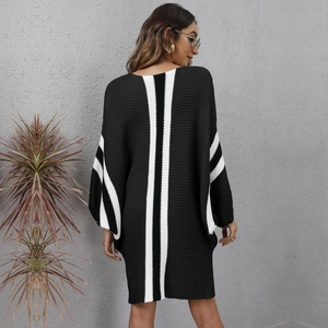 Back view of a knit dress featuring bold white stripes and a modern oversized silhouette