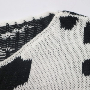 Dettaglio del colletto in maglia jacquard bianca e nera di alta qualità su questo maglione