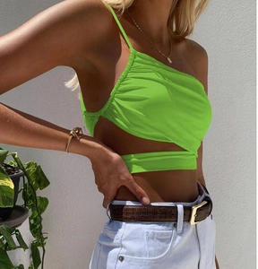 Detail of neon green irregular crop top with side ruching and waist cutout design