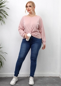 Detail showing the stylish front knot hem on a pink long sleeve casual top