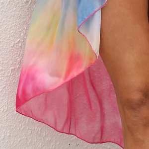 Close-up of vibrant tie-dye mesh fabric with colorful gradient and delicate edge stitching