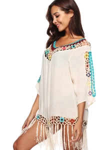 Detailed view of colorful crochet rings and fringe hem on a boho beach cover-up dress