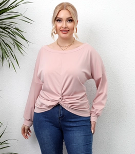 Detail of plus size pink top featuring a unique knotted hem and ribbed cuff sleeves