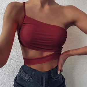 Detail of wine red slim fit top with one-shoulder strap and geometric waist cut-out