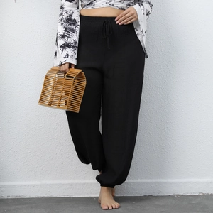 Detail of black drawstring waist and textured fabric on casual loose harem beach pants