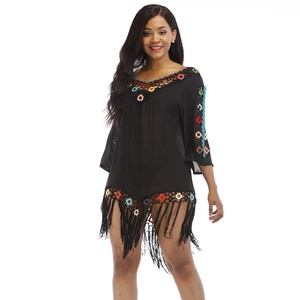 Detail of bohemian black beach cover-up with colorful crochet patterns and long tassels