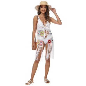 Détail d'un cache-maillot en crochet blanc avec motifs tournesol colorés et franges longues