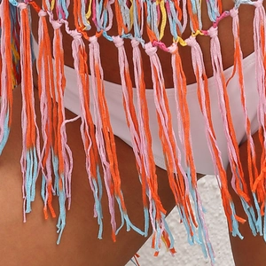Détail d'un cache-maillot de plage au crochet bohème avec des pompons colorés