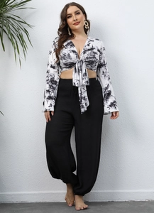 Detail showing the chic marble tie-dye V-neck crop top and black high waist trousers