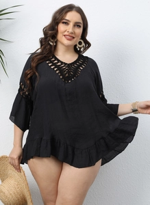 Detail of crochet neckline and ruffled hem on a black plus size beach cover-up