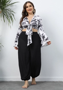 Detail view of plus size black high waisted lantern pants with elastic cuffs and texture