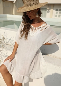 Dettaglio del vestito bianco da spiaggia con pizzo all'uncinetto e orlo a balze