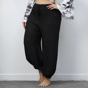 Detail of plus size black harem pants showing drawstring waist and textured fabric