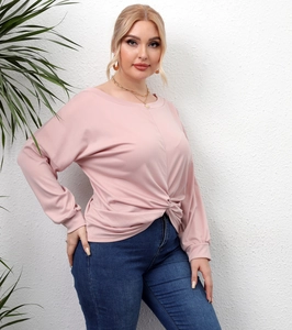 Detail of the unique twist knot design on a casual pink long-sleeve women's top