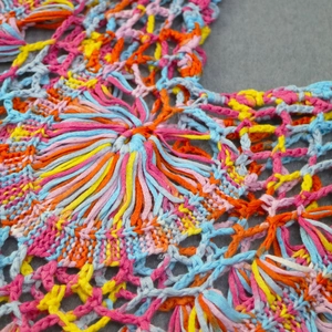 Gros plan sur la robe en crochet colorée faite main montrant des motifs ajourés
