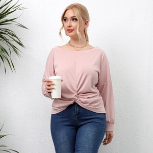 Detail of light pink long sleeve top featuring twist knot hem and off-shoulder neckline