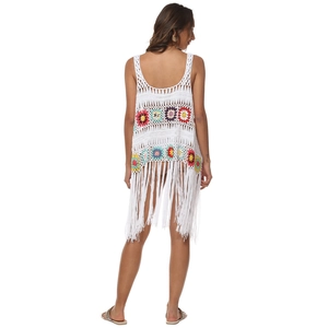 Détail du motif de tournesol au crochet et longues franges sur cardigan de plage blanc boho