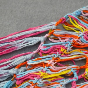 Vue macro de glands colorés crochetés à la main et texture en maille d'une robe de plage