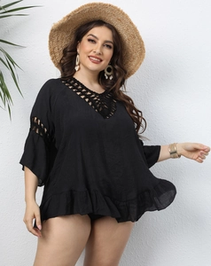 Detailed close-up of black crochet v-neck and hollow-out lace details on beach cover-up