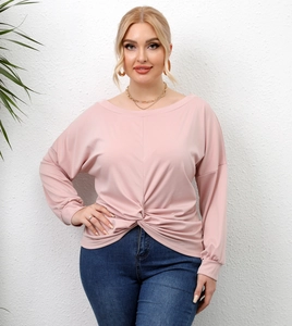 Detail of plus size pink crossover top with twist knot hem and elegant boat neck
