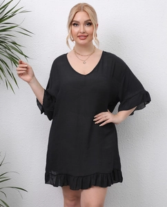 Detail of ruffle hem and lightweight black fabric on loose V-neck beach cover-up dress