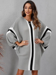 Detail of loose-fit knitted dress featuring batwing sleeves and striped color-block patterns