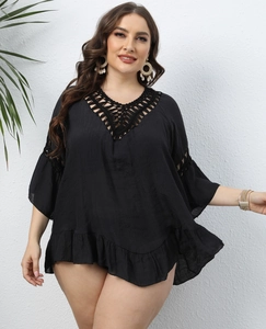 Detail of plus size black beach cover-up with crochet deep V-neck and ruffle hem