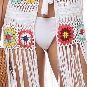 Gros plan sur le haut de plage en crochet bohème avec fleurs colorées et longues franges