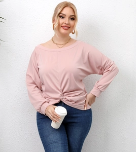 Detail view of the elegant twist knot hem on this pale pink long sleeve casual top