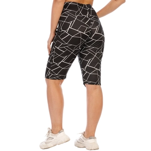 Detail of high-waisted black biker shorts with white irregular geometric print pattern