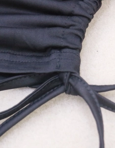 Close-up of black drawstring cord and pleated fabric texture on a slim-fit crop top
