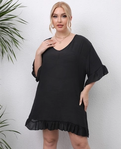 Detail of plus size black V-neck beach dress showing the ruffled hem and textured fabric
