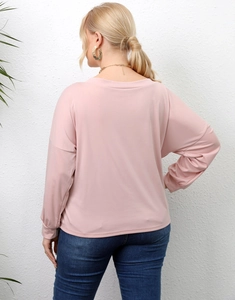 Detail of light pink long sleeve top with irregular back cut and relaxed fit for women