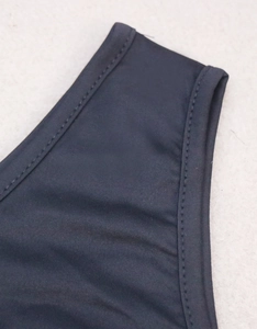 Detail of black knitted fabric with double-needle stitching on the shoulder strap area